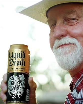 A man in a cowboy hat holding a can of Liquid Death Sweet Reaper